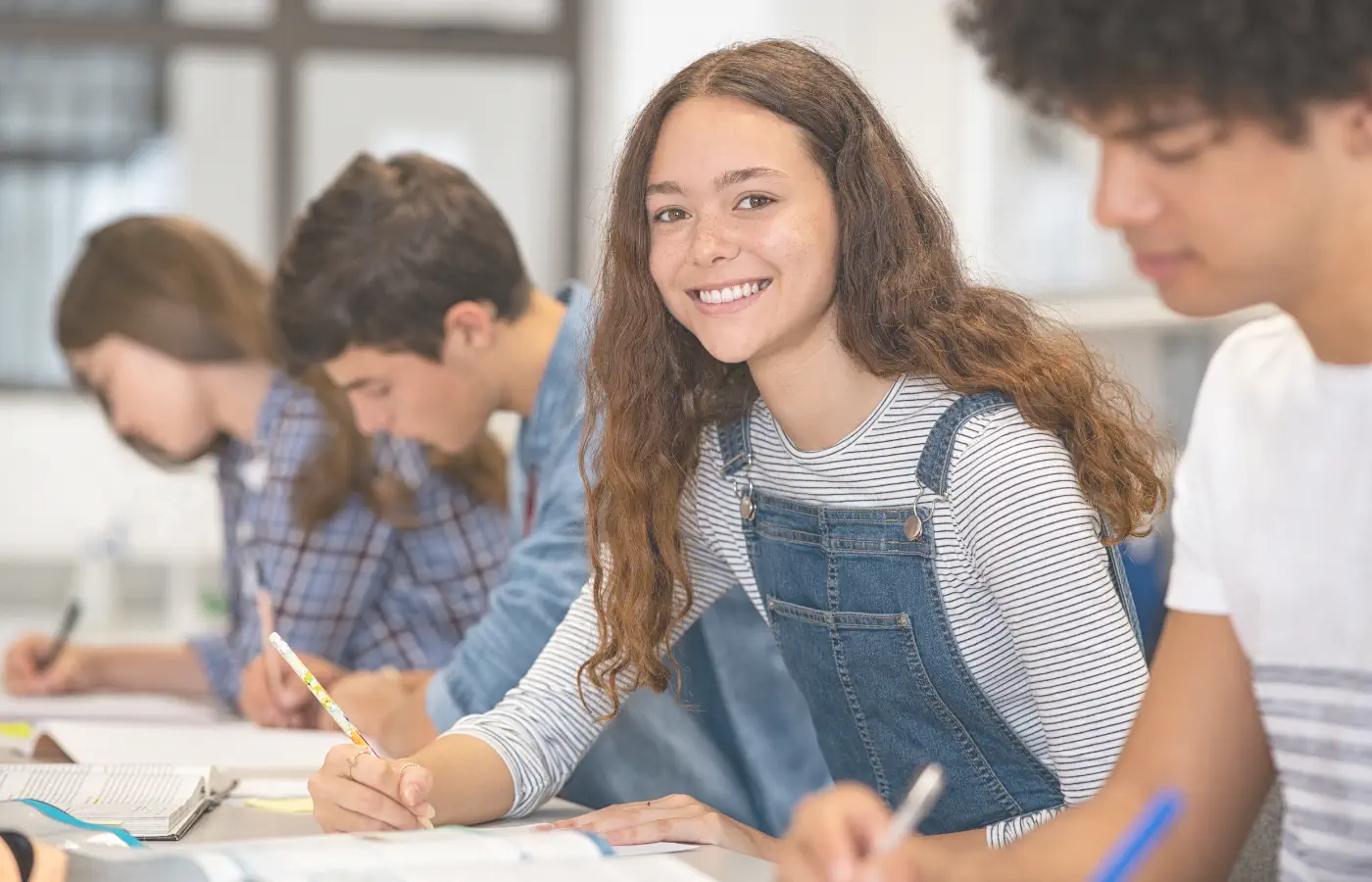 Adolescente souriante en classe avec ses camarades, après un accompagnement en coaching scolaire à Clermont-Ferrand