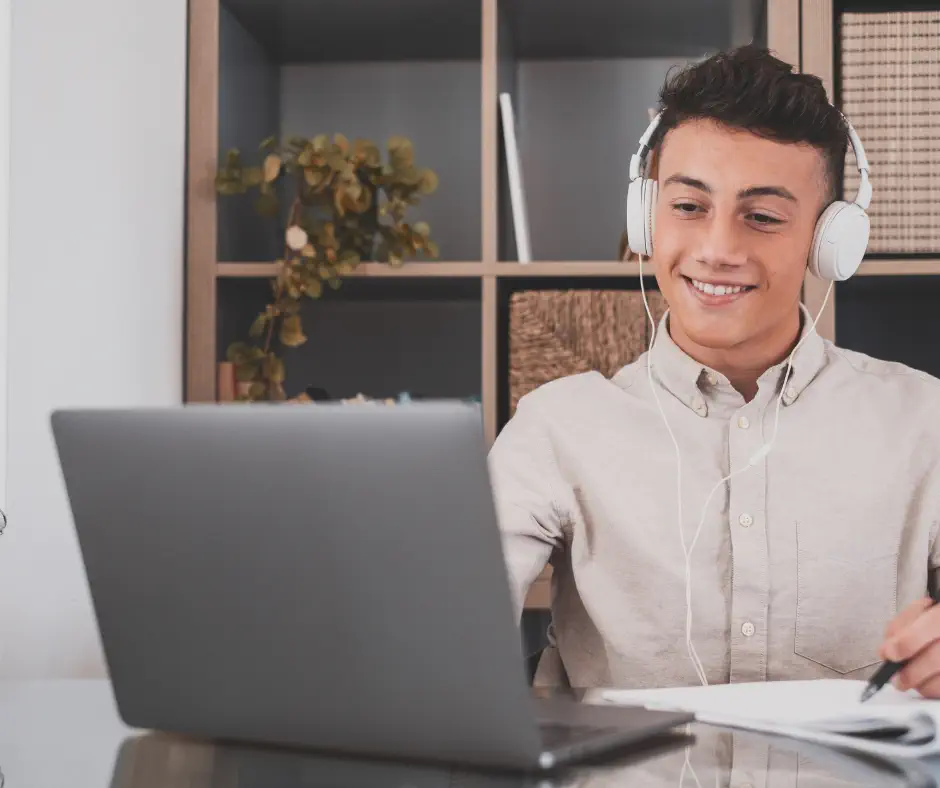 Adolescent en séance de coaching scolaire en visio, casque sur les oreilles